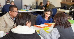 One man and three women sit around a table discussing NDIS during a workshop
