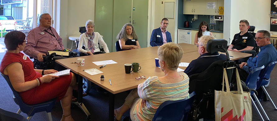 Participants on PDCN consultation with people with disability sit around a table talking