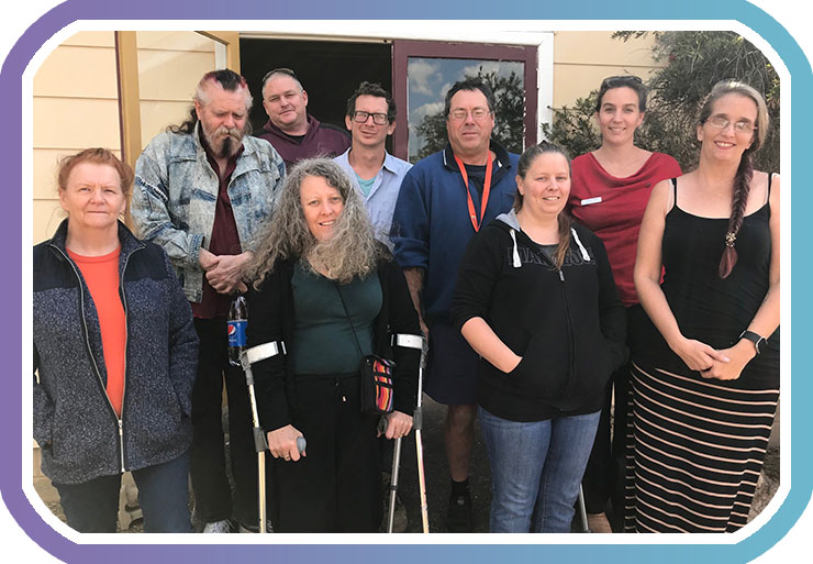 nine members of Kyogle peer group pose for camera outside meeting room