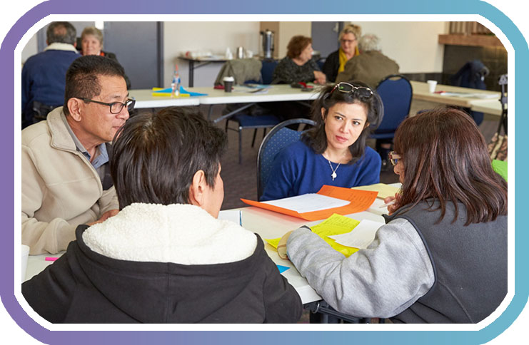 FOur participants of ndis workshop discuss around a table